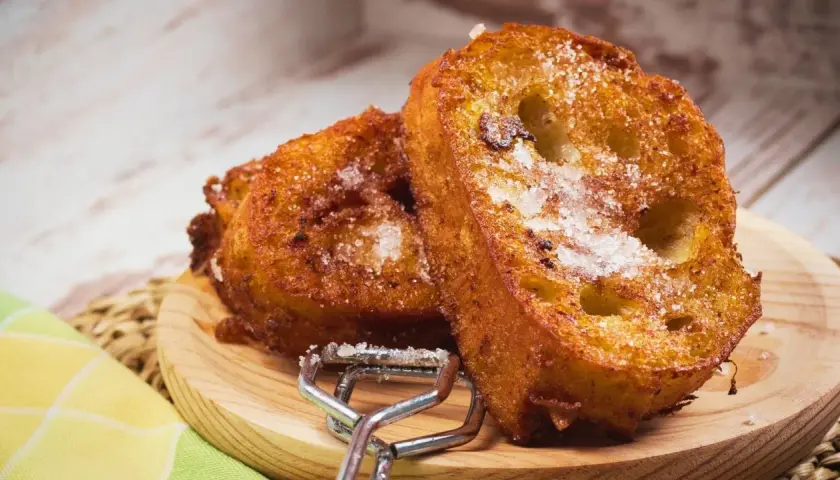 Dos deliciosas torrijas espolvoreadas con azúcar, listas para disfrutar. Perfectas para tu receta de torrijas con miel.