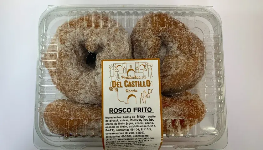 Roscos fritos azucarados en un envase transparente. La etiqueta indica "Productos Del Castillo Ronda" y "Rosco Frito".