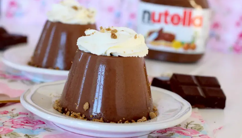 Deliciosa panna cotta de Nutella, coronada con crema batida y migas crujientes. Un postre irresistible.
