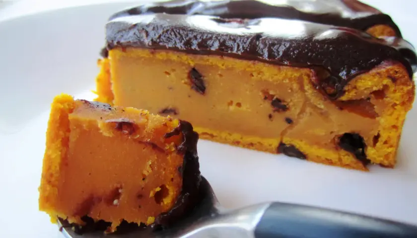 Deliciosa tarta de calabaza y chocolate, con un trozo en una cuchara listo para ser degustado.