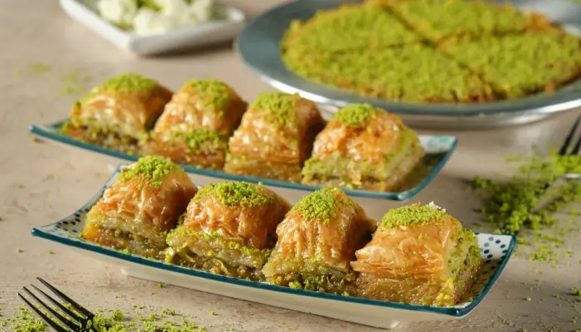 Delicioso baklava, una receta tradicional con capas crujientes y relleno de pistacho, espolvoreado con más pistacho verde.