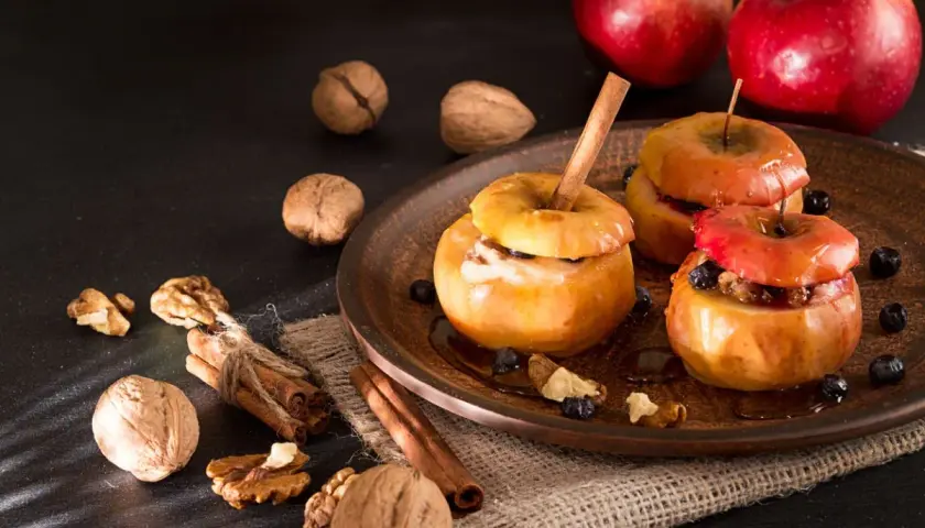 Deliciosas manzanas al horno con canela, nueces y arándanos, un postre casero perfecto para el otoño.