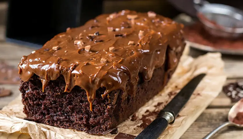 Deliciosa coca de chocolate casera, cubierta con glaseado de chocolate y trocitos de cacao. Perfecta para un antojo dulce.