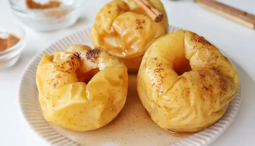 Manzanas asadas al microondas, tiernas y dulces, espolvoreadas con canela y bañadas en su propio jugo.
