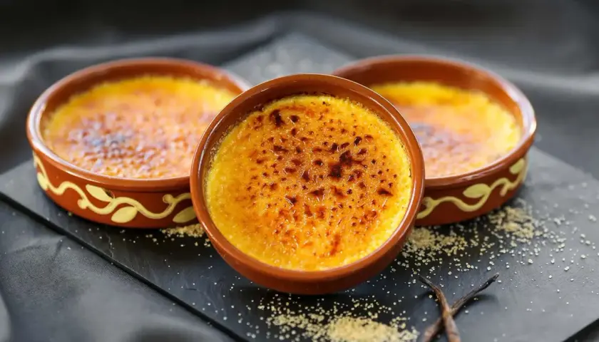 Tres deliciosas cremas catalanas recién hechas, con su capa crujiente de caramelo tostado, listas para ser disfrutadas.