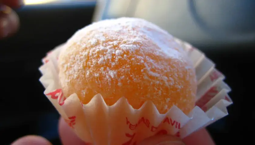 Dulce naranja cubierto de azúcar glas, listo para disfrutar. Una delicia que recuerda a la yemas de Santa Teresa receta.