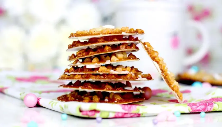 Deliciosas moscovitas receta, crujientes y doradas, apiladas sobre un mantel floral.