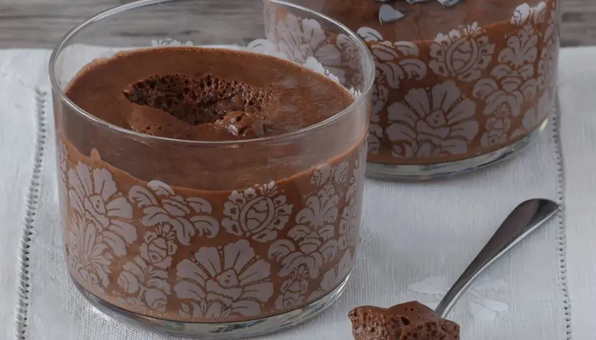 Delicioso mousse de nata de chocolate en copas decoradas. Una cucharada lista para saborear.