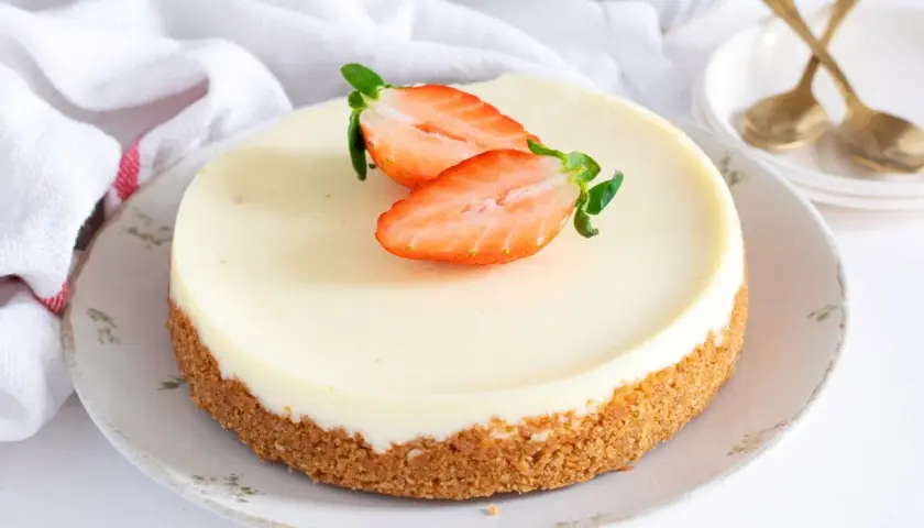 Tarta de cuajada cremosa con base crujiente y fresas frescas. Un postre delicioso y elegante.
