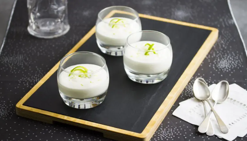 Tres vasitos de postre cremoso, perfectos para aprender como se hace el mus de limon. Decorados con ralladura verde.