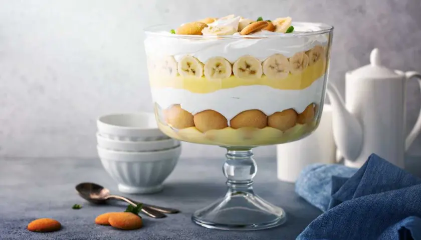 Delicioso pudin de platano en capas, con galletas y crema batida, listo para servir.