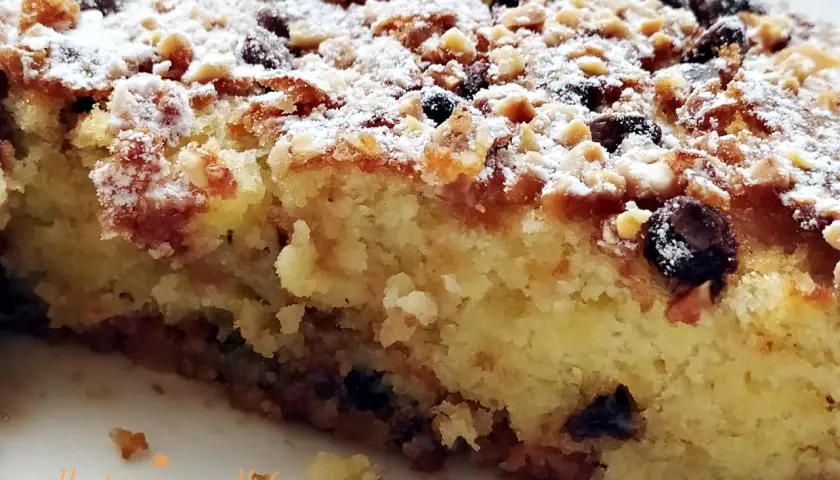 Deliciosa coca de Castellón con frutos secos y azúcar glas, perfecta para acompañar un café.
