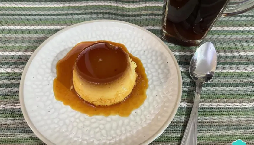 Delicioso flan napolitano bañado en caramelo, listo para disfrutar con una taza de café.