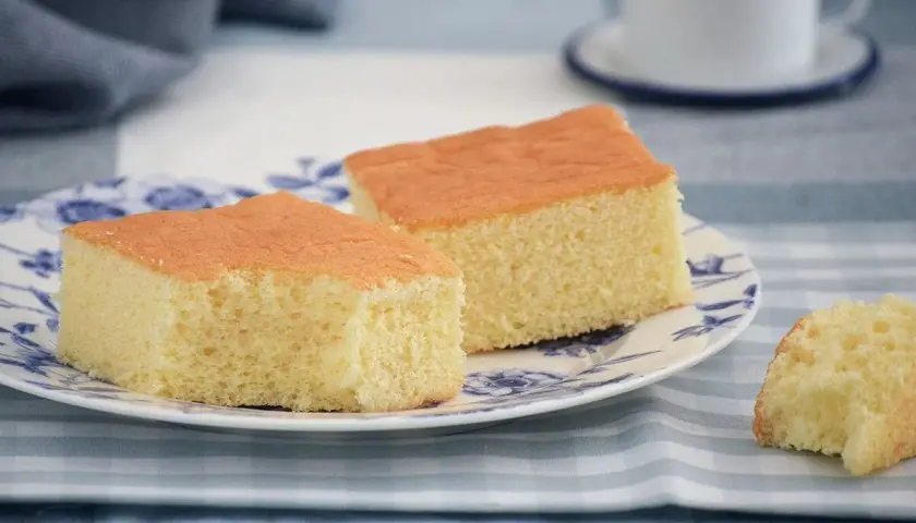 Dos porciones de pa de pessic esponjoso y dorado en un plato con diseño floral azul.