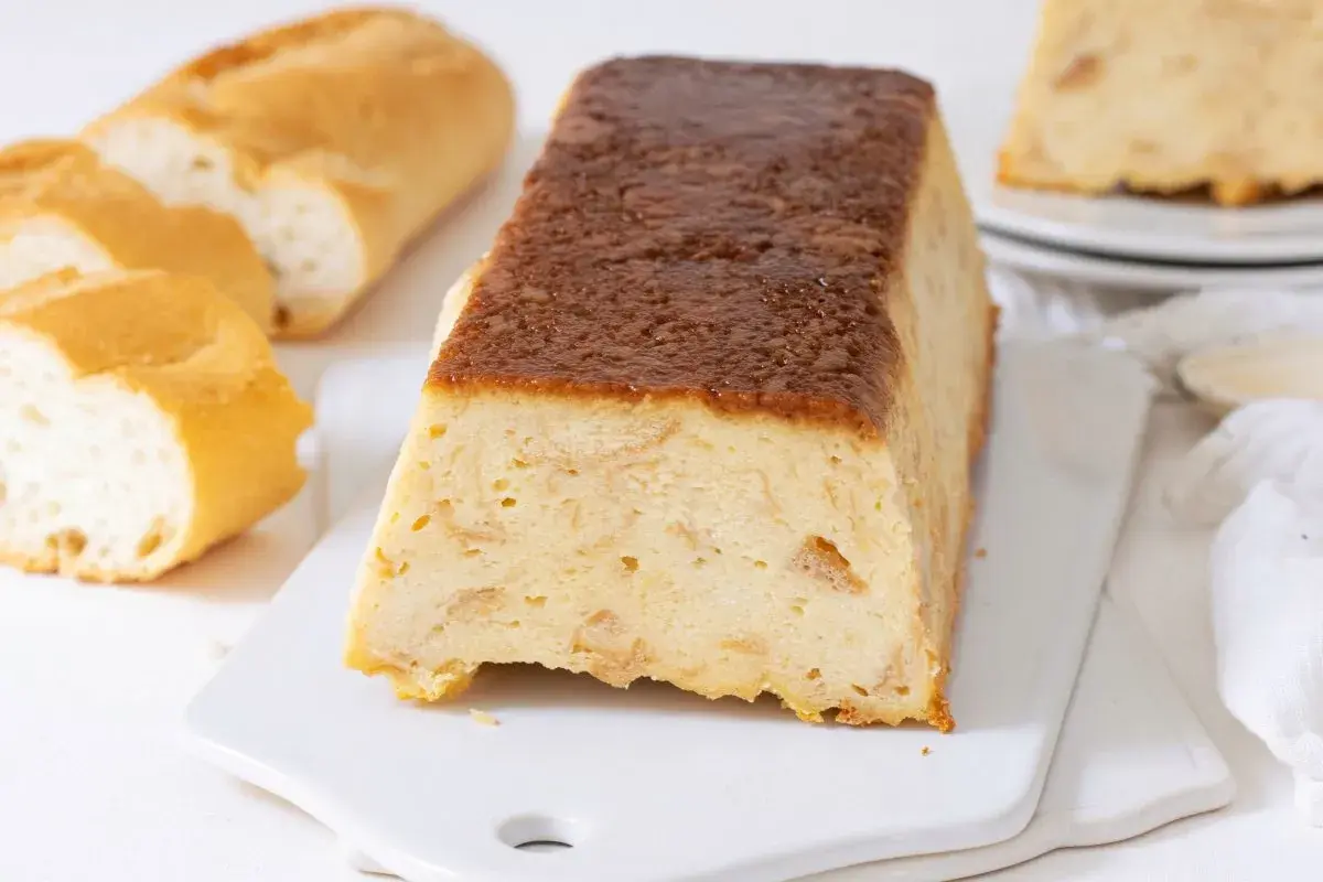 Un delicioso pudin de pan duro, con trozos de pan crujiente y una cobertura dorada.