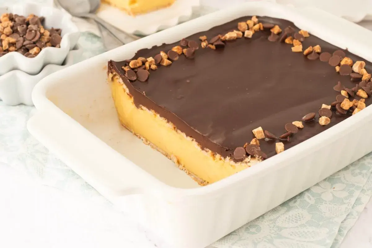 Tarta de galletas de la abuela de toda la vida, con capa de crema y cobertura de chocolate, decorada con trocitos de galleta y chocolate.