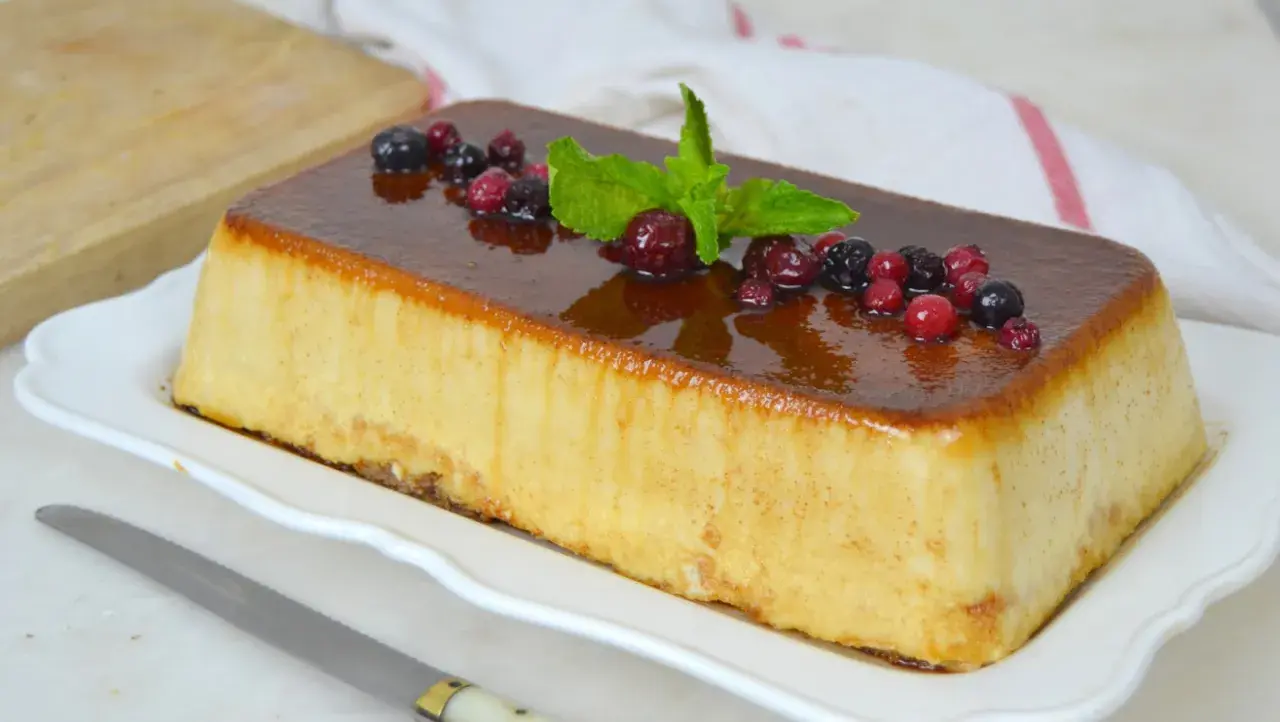 Deliciosa tarta de la abuela con sobaos, cubierta de caramelo y decorada con frutos rojos y menta.