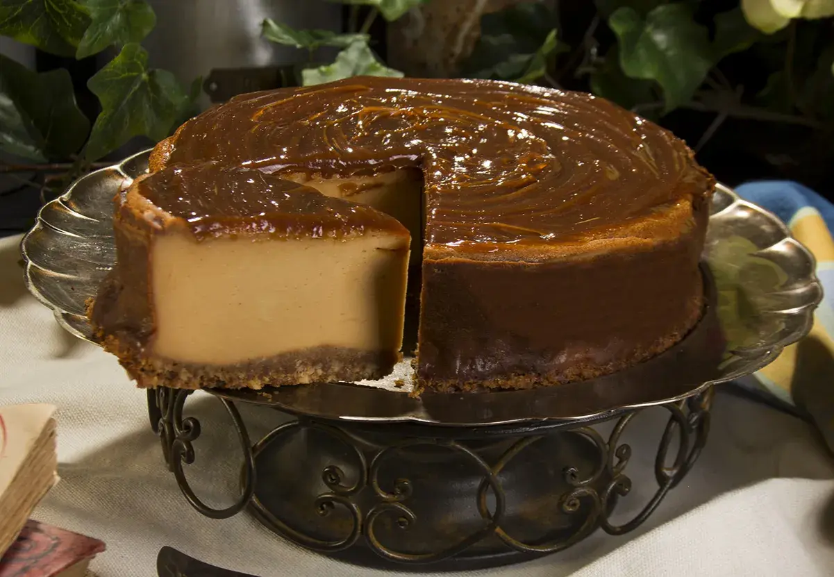 Tarta de dulce de leche, cremosa y dorada, con un glaseado brillante que invita a probarla.