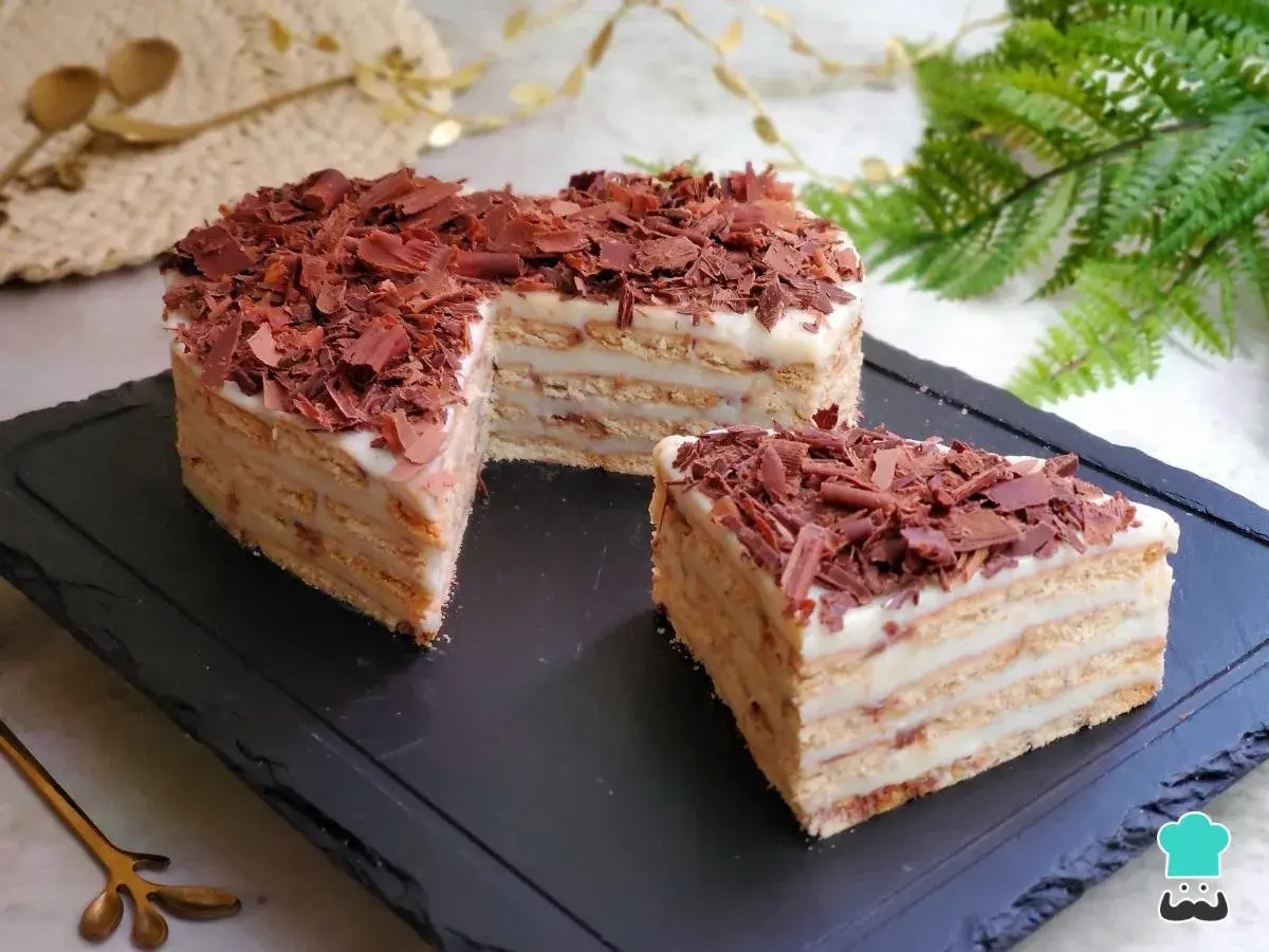 Deliciosa tarta del abuelo, con capas de galleta y crema, cubierta de virutas de chocolate. ¡Un postre casero irresistible!
