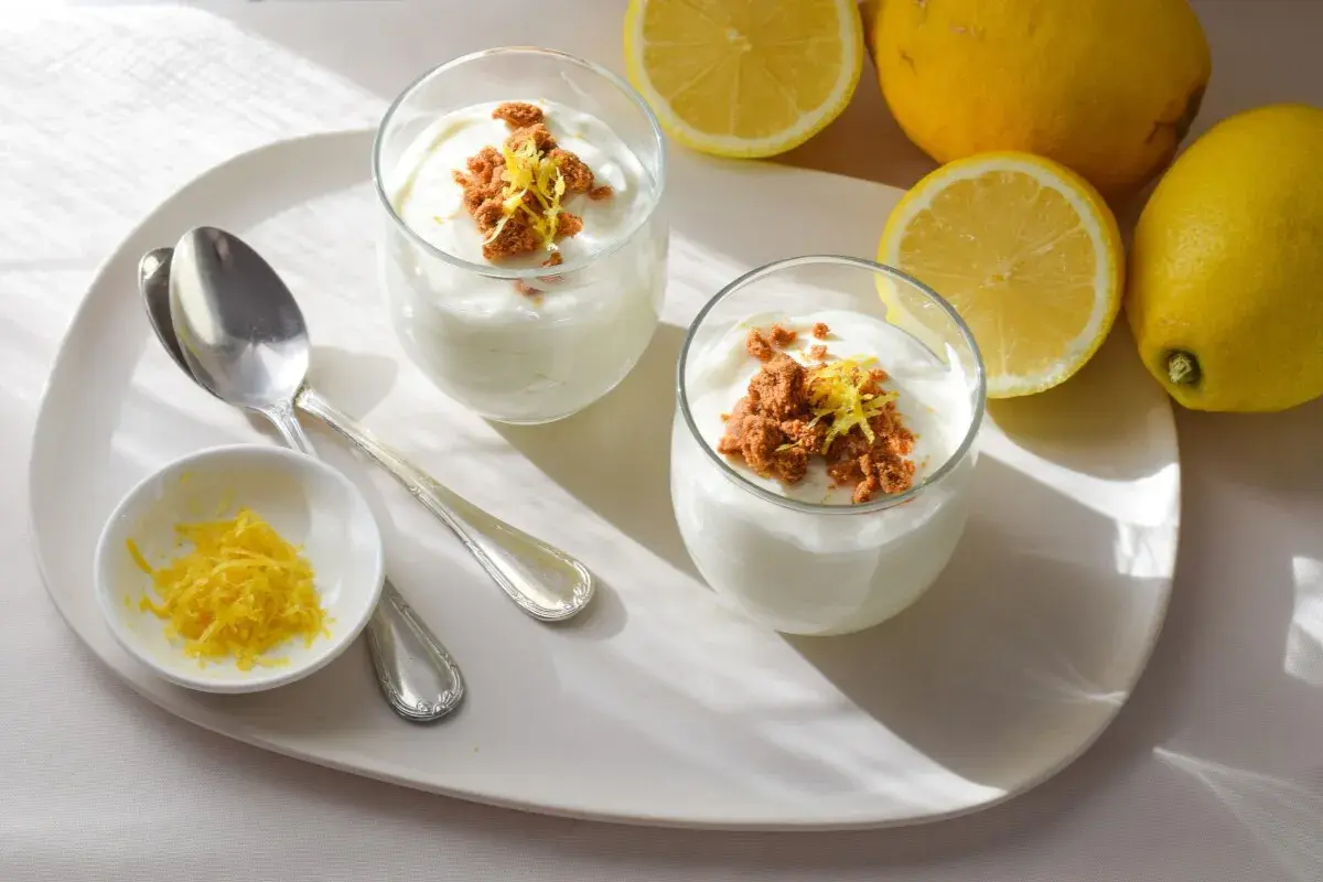 Delicioso mousse de limón con yogur, coronado con migas crujientes y ralladura de limón fresco.
