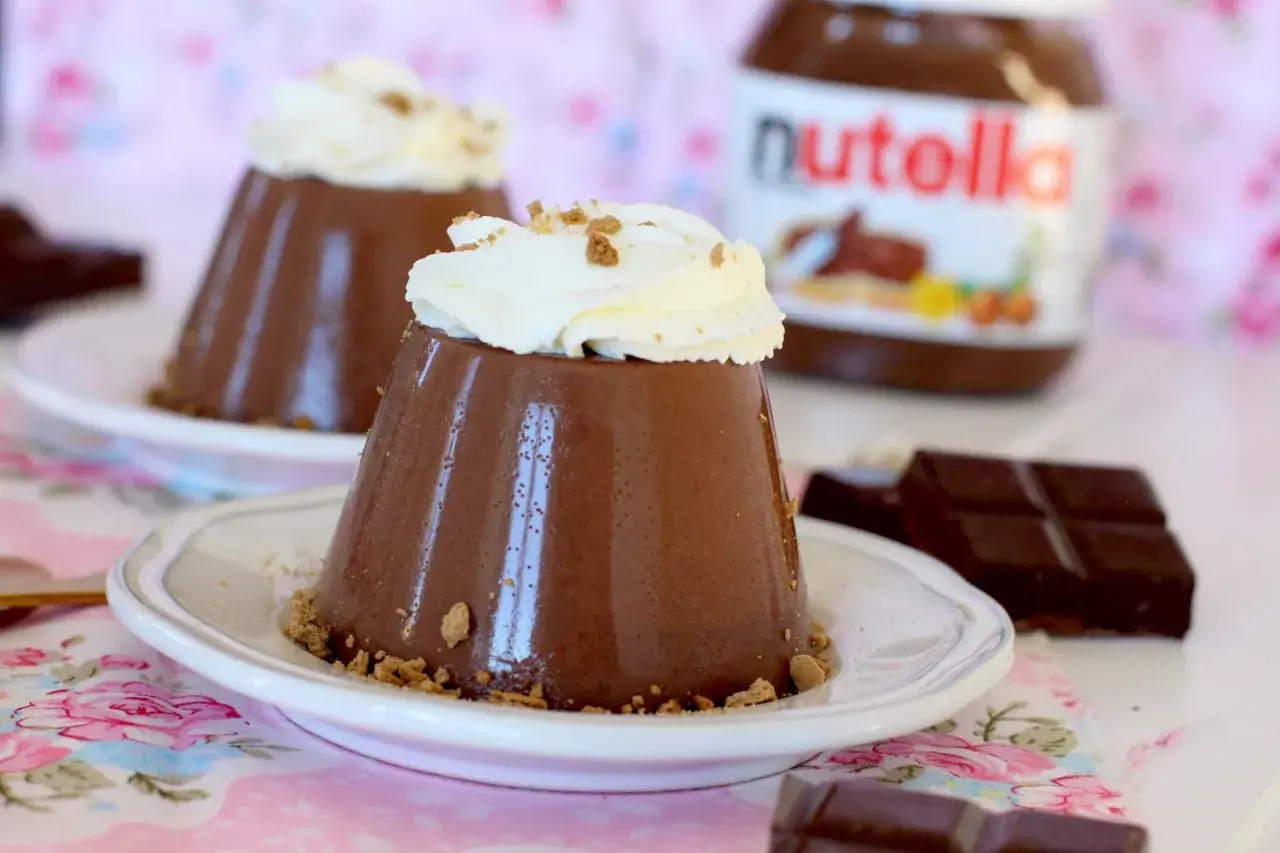 Deliciosa panna cotta de Nutella, coronada con crema batida y migas crujientes. Un postre irresistible.