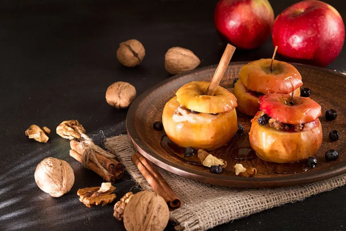Deliciosas manzanas al horno con canela, nueces y arándanos, un postre casero perfecto para el otoño.