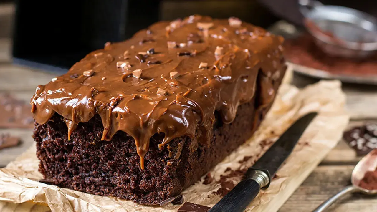 Deliciosa coca de chocolate casera, cubierta con glaseado de chocolate y trocitos de cacao. Perfecta para un antojo dulce.