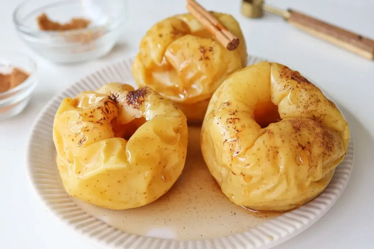Manzanas asadas al microondas, tiernas y dulces, espolvoreadas con canela y bañadas en su propio jugo.