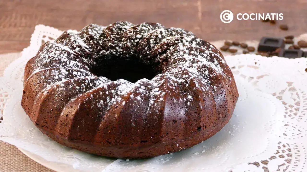 Bizcocho de café oscuro, con forma de rosca, espolvoreado con azúcar glas. Perfecto para acompañar un café.