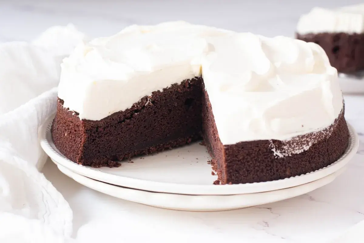 Tarta Guinness de chocolate oscuro con glaseado blanco cremoso, lista para ser disfrutada.