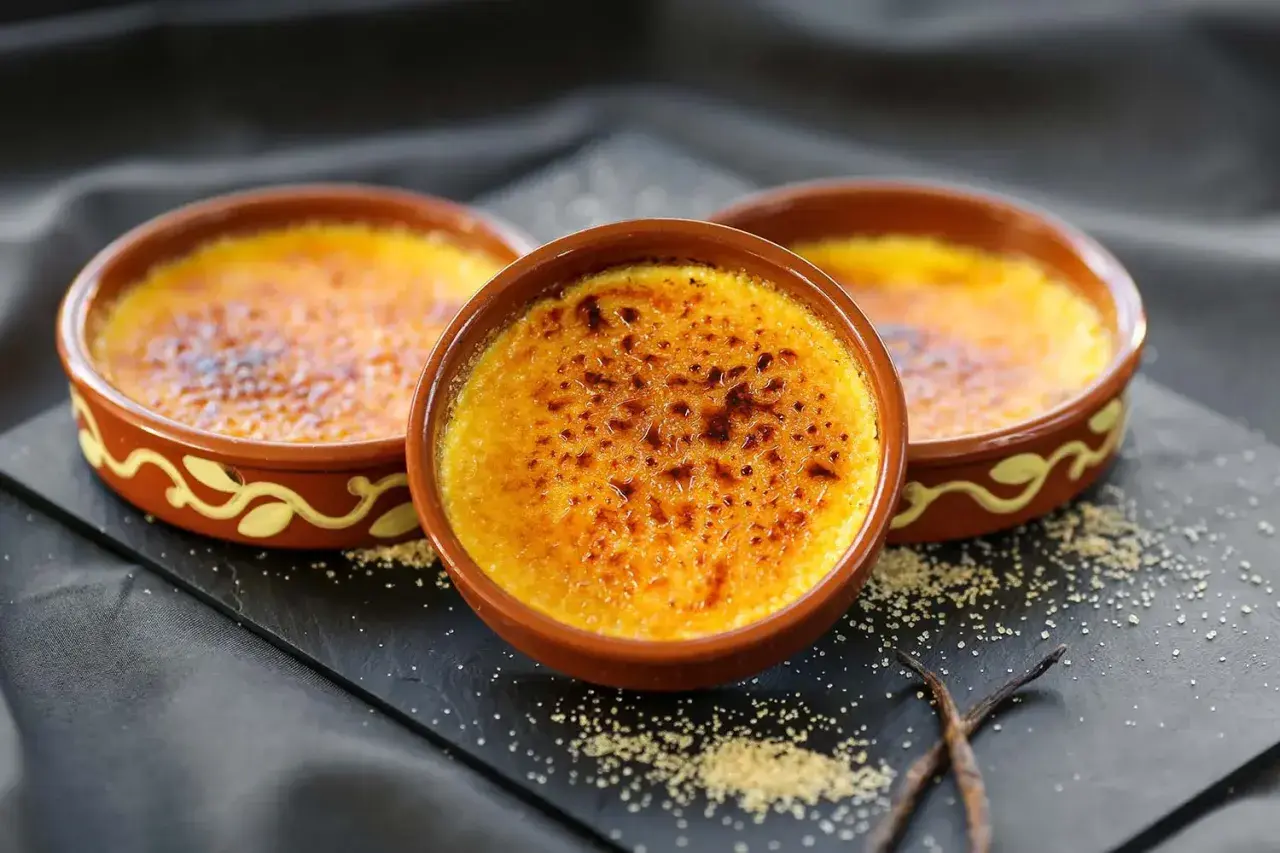 Tres deliciosas cremas catalanas recién hechas, con su capa crujiente de caramelo tostado, listas para ser disfrutadas.