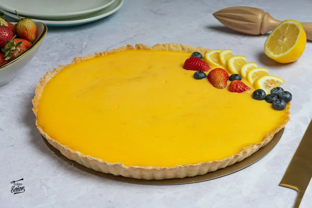 La mejor tarta de limón, con una crema amarilla vibrante y decorada con fresas, arándanos y rodajas de limón. ¡Un postre irresistible!