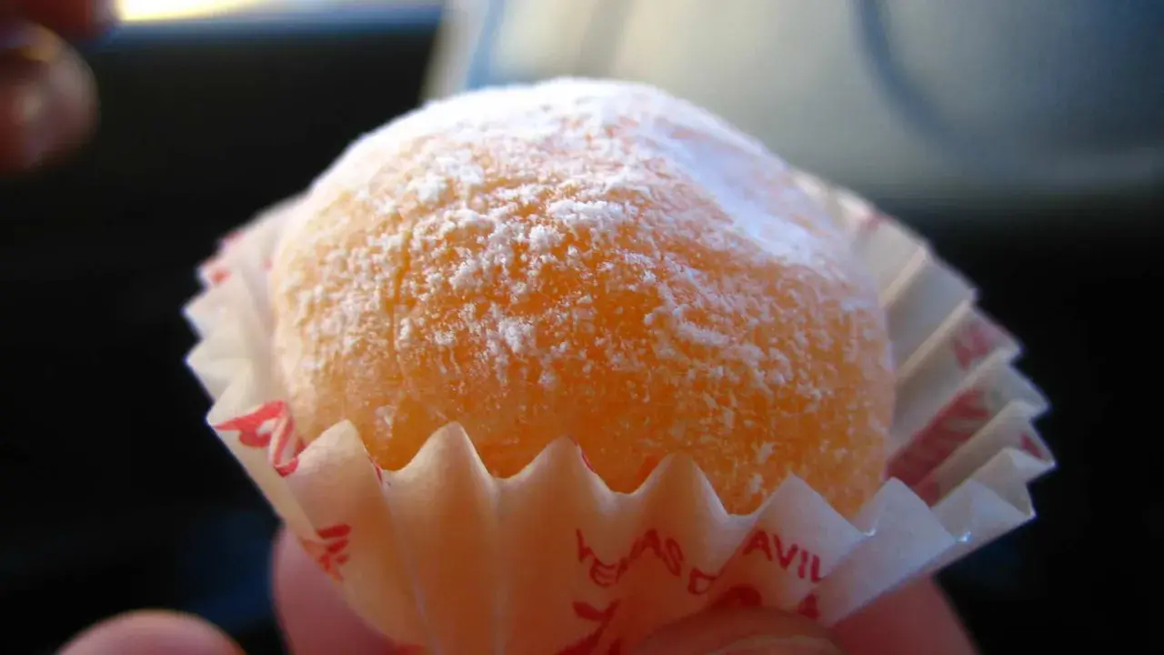 Dulce naranja cubierto de azúcar glas, listo para disfrutar. Una delicia que recuerda a la yemas de Santa Teresa receta.