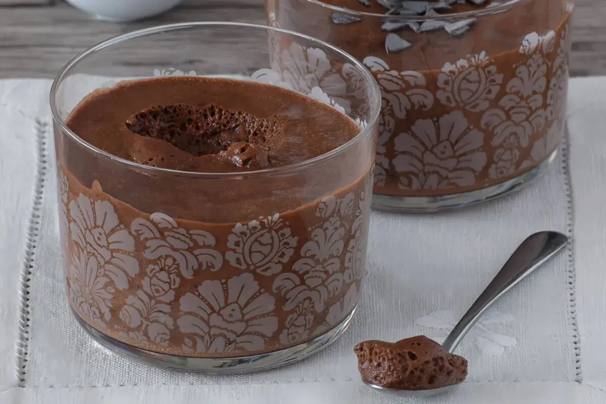 Delicioso mousse de nata de chocolate en copas decoradas. Una cucharada lista para saborear.