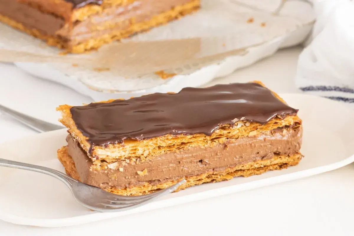Delicioso milhojas de chocolate con capas crujientes de hojaldre y crema de cacao, listo para disfrutar.