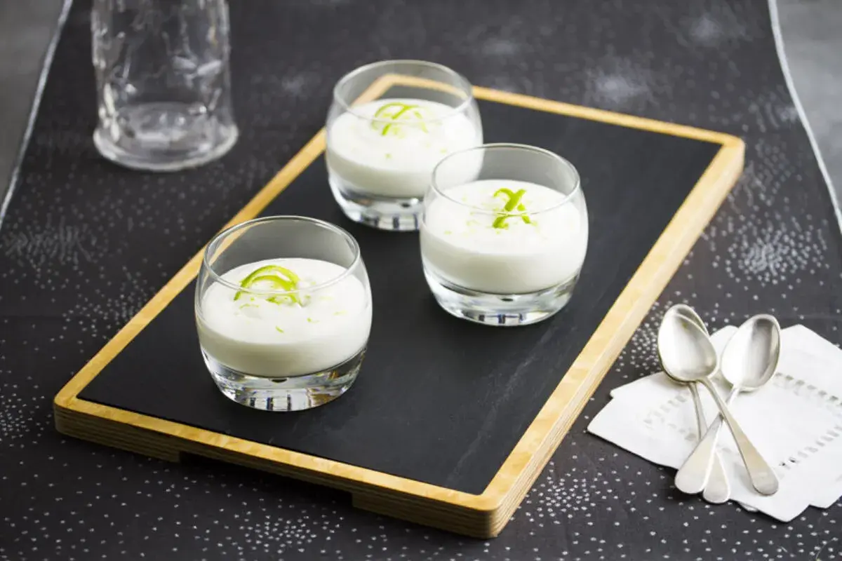 Tres vasitos de postre cremoso, perfectos para aprender como se hace el mus de limon. Decorados con ralladura verde.