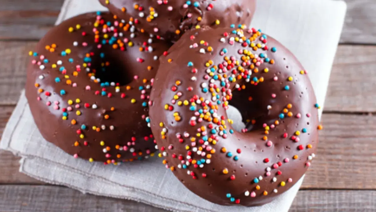 Deliciosos donuts de calabaza y chocolate cubiertos con chispas de colores, listos para disfrutar.