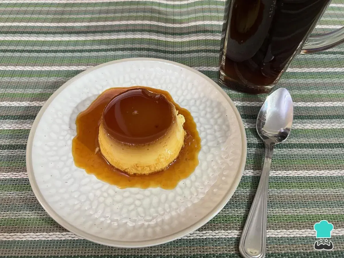 Delicioso flan napolitano bañado en caramelo, listo para disfrutar con una taza de café.
