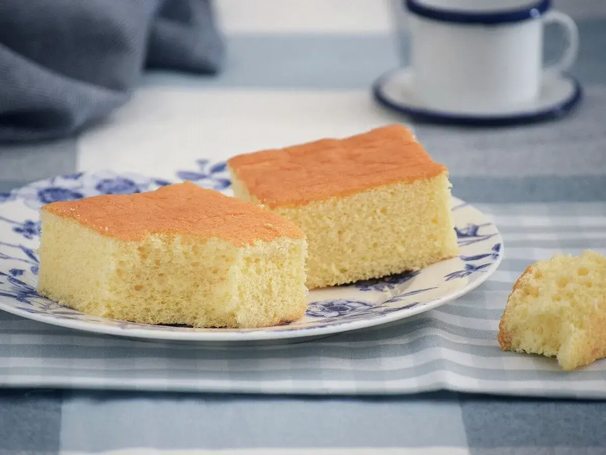 Dos porciones de pa de pessic esponjoso y dorado en un plato con diseño floral azul.