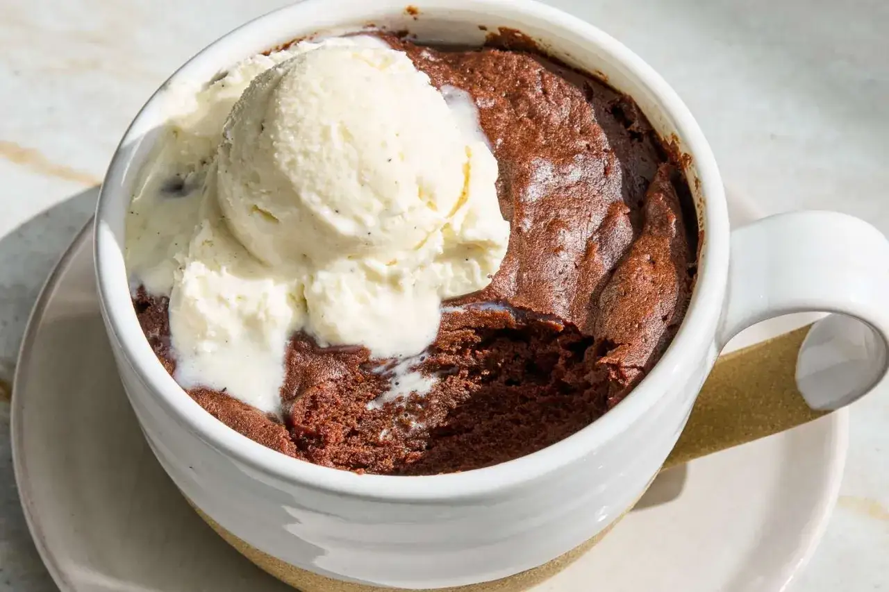 Delicioso brownie de microondas recién hecho, con una bola de helado de vainilla derritiéndose encima.