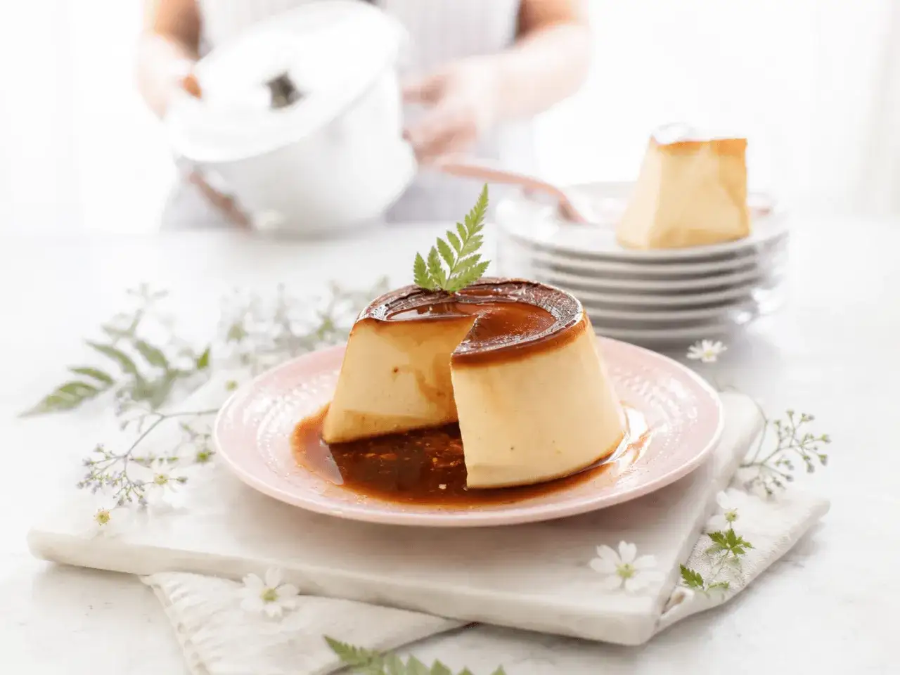 Delicioso flan de leche condensada con caramelo l&iacute;quido, decorado con una ramita verde.
