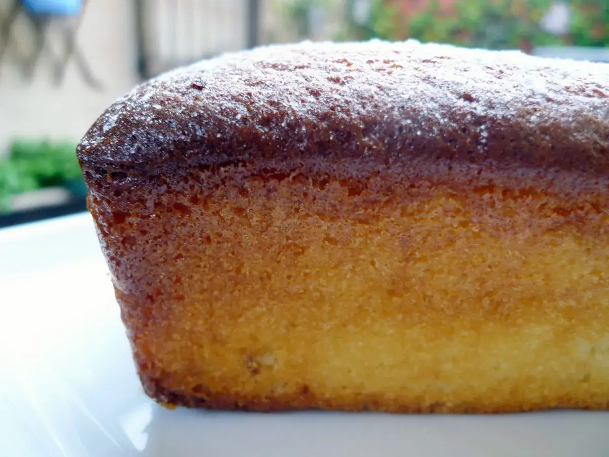 Bizcocho de leche condensada, dorado y esponjoso, espolvoreado con az&uacute;car glas.