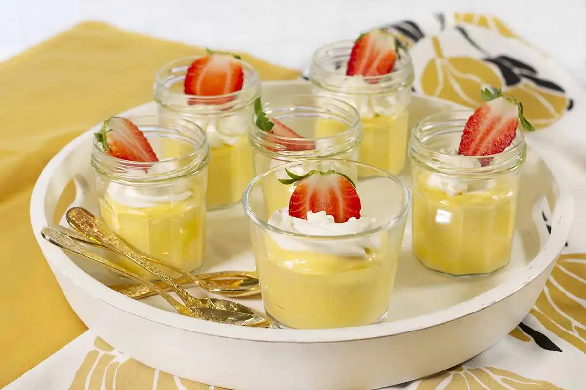 Delicioso mousse de nata en vasitos, coronado con fresa y nata montada. ¡Un postre perfecto para cualquier ocasión!