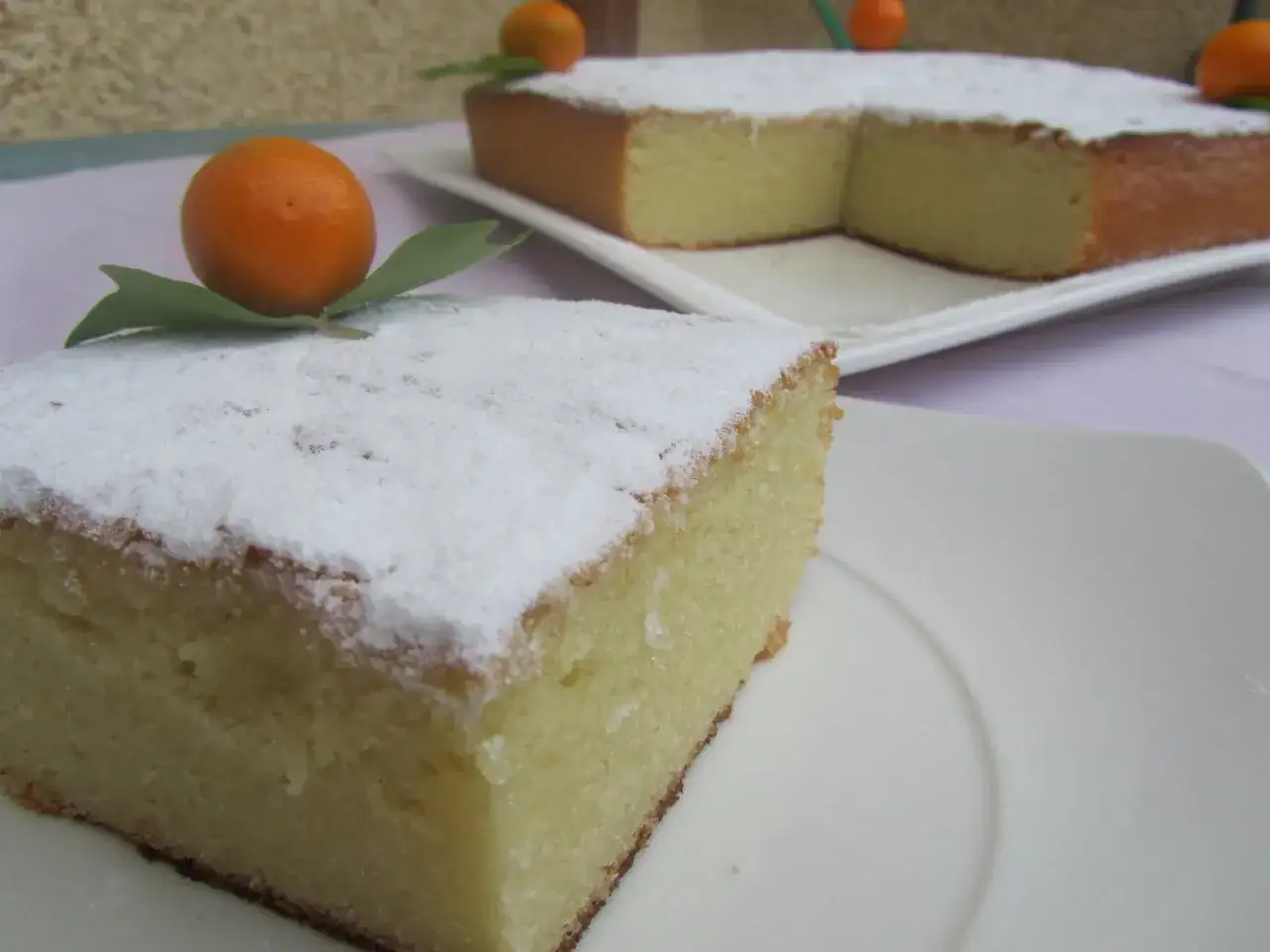 Deliciosa coca de Castell&oacute;n espolvoreada con az&uacute;car glas y decorada con mandarinas.