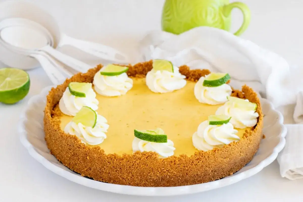 Delicioso key lime pie con crema batida y rodajas de lima, listo para disfrutar.