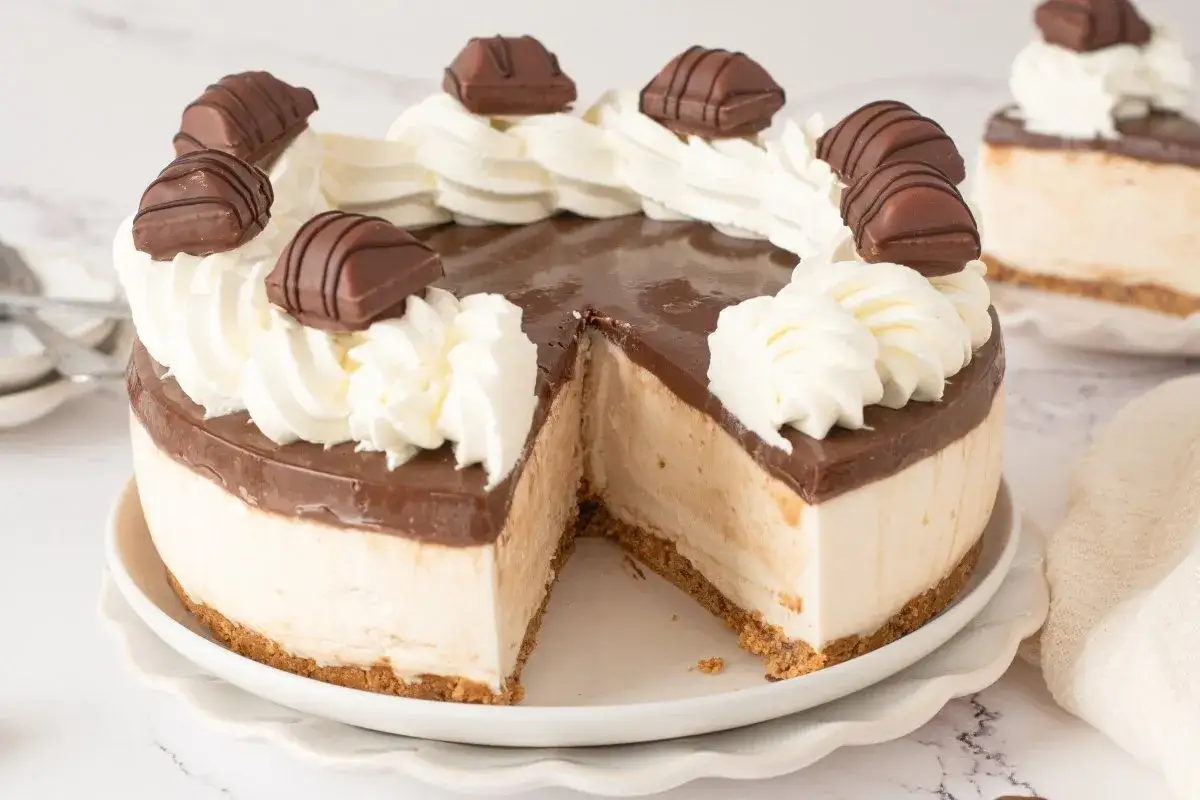 Tarta Kinder Bueno con crema batida y trozos de chocolate, lista para disfrutar.