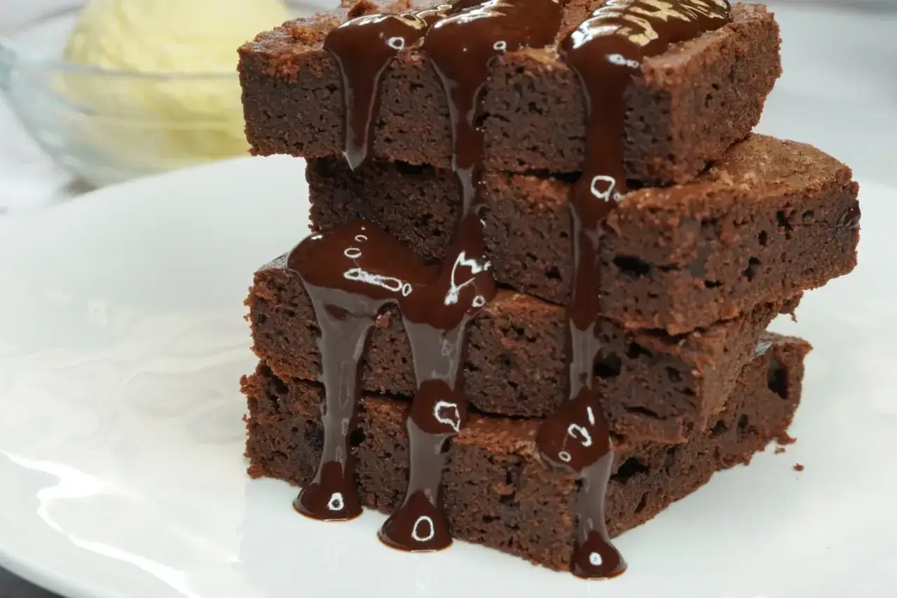 Una pila de deliciosos brownies de chocolate, cubiertos con salsa de chocolate derretida. &iexcl;La receta de brownie esponjoso perfecta para cualquier ocasi&oacute;n!