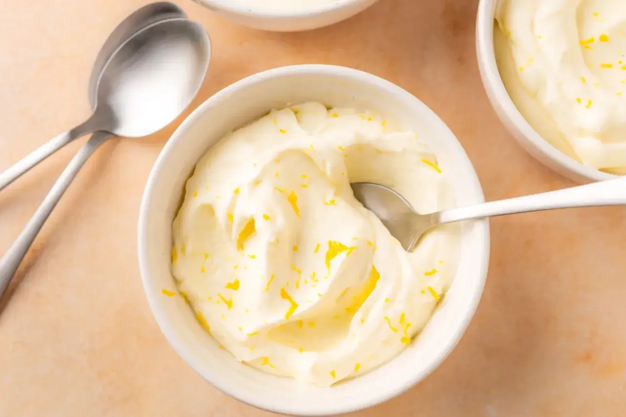 Delicioso mousse de lim&oacute;n con yogur, adornado con ralladura de lim&oacute;n, listo para disfrutar.