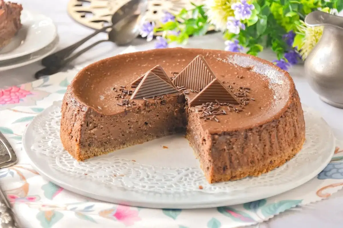 Deliciosa tarta de queso y chocolate, decorada con pirámides de chocolate y virutas. Un postre irresistible.