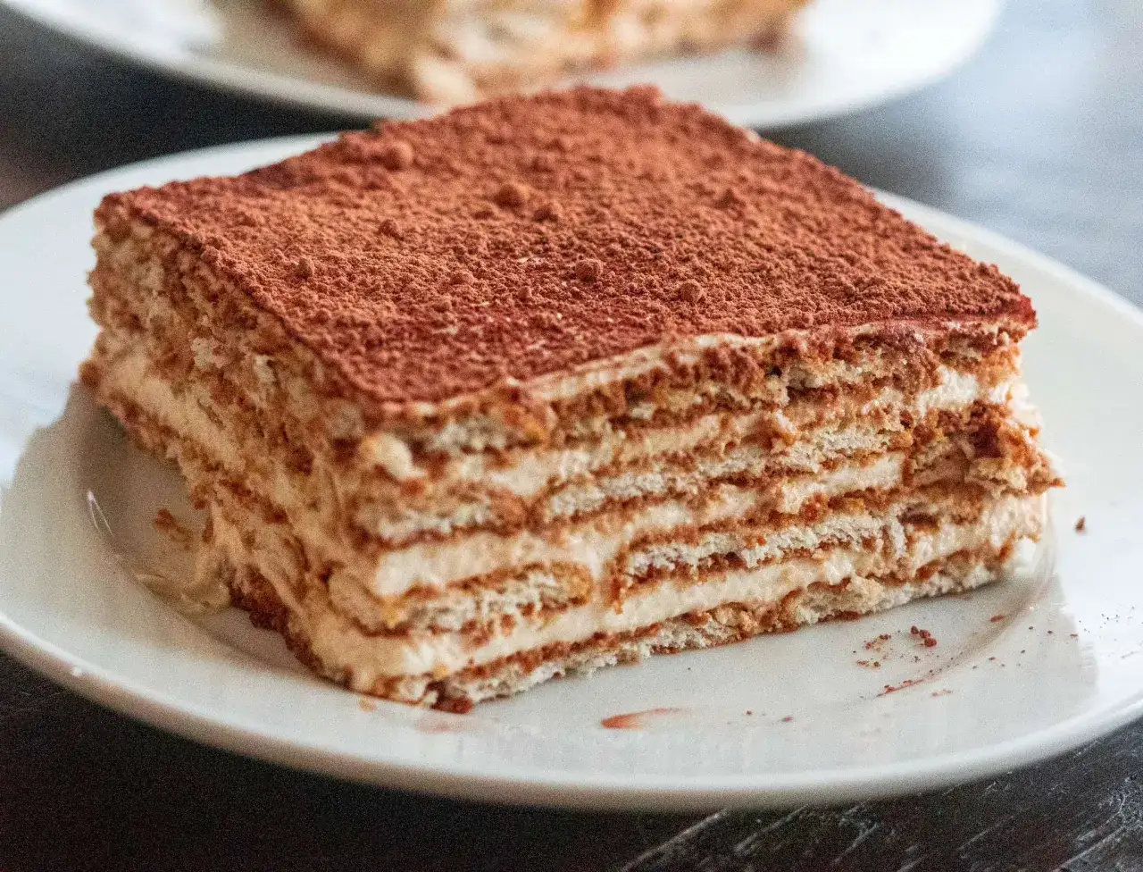 Deliciosa tarta de galletas y caf&eacute;, con capas de crema y espolvoreada con cacao. Un postre perfecto para disfrutar en cualquier momento.